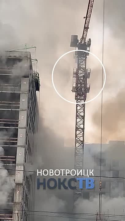 Крановщик сам спускается с крана, окутанного дымом