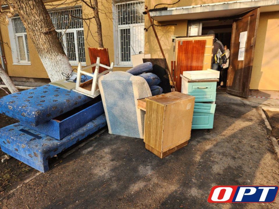 Волонтеры вместе с жильцами выносят из пострадавших, во время пожара, квартир вещи и мебель, пришедшие в негодность